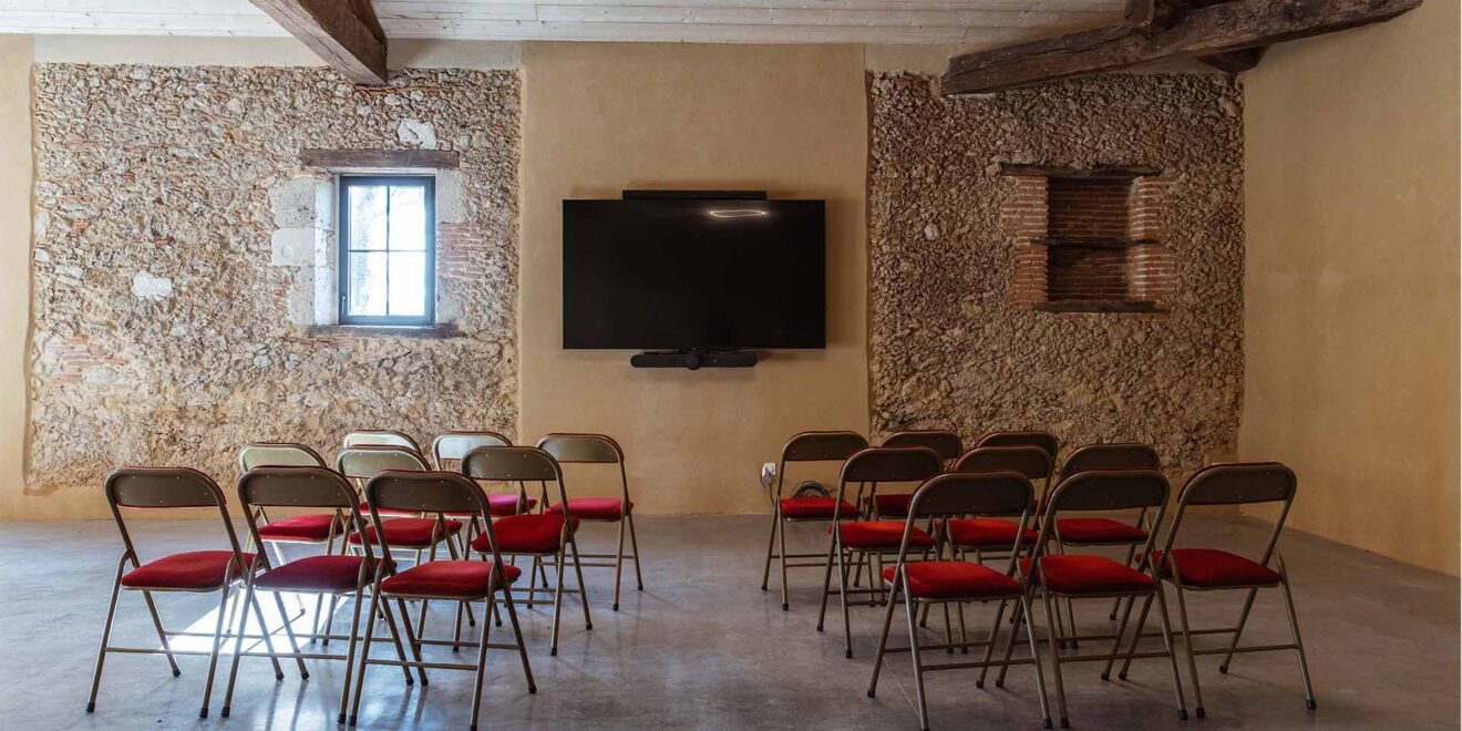 photo de la salle de séminaire avec des chaises donnant sur le vidéo projecteur