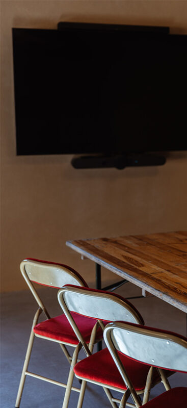Salle de réunion avec chaises, télévision et une table.